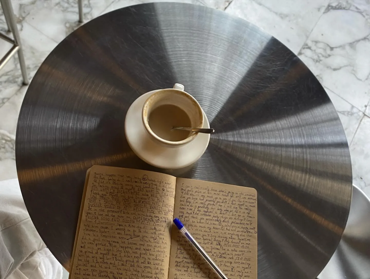A coffee and a handwritten notebook on a record