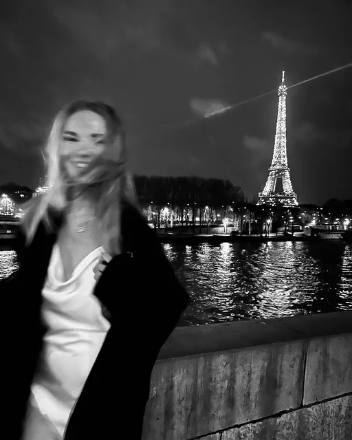 sofia by the Seine at night, the Eiffel Tower behind her